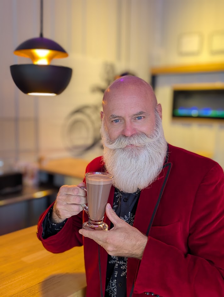 The Dapper Santa in a modern red jacket holding a holiday drink