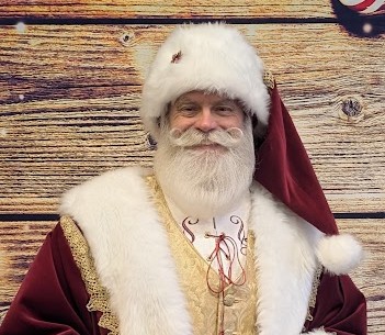 Santa in a traditional velvet hat and fur-trimmed vest